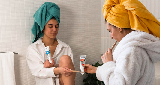 Two women using ATTITUDE natural fluoride toothpaste for a good dental health during their night time routine